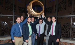 Several students hold a large replica of the HSU class ring.