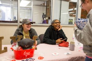 Members of the HSU Love Your Melon crew speak with a student about their organization.