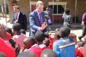 Grey Hoff high-fives local Kenyan children.