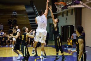 A men's basketball player scores.