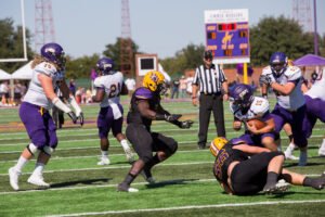 HSU football players in a game against UMHB.