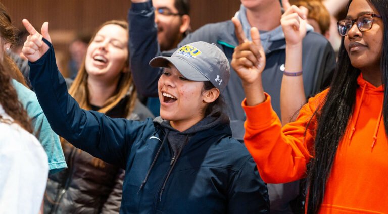 Students do the HSU cheer in chapel.