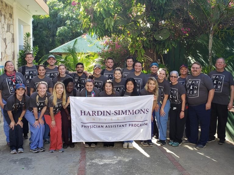 Students from the Master of Physician Studies program hold their school flag during a mission trip to Dominican Republic.