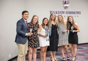 A group of award recipients pose for a picture after recieving their awards.