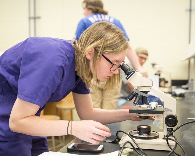 Student looks through microscope