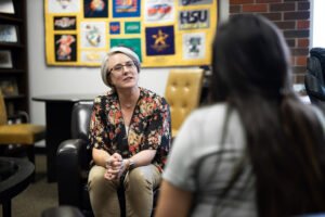 Stacey Martin speaks with a student in her office.