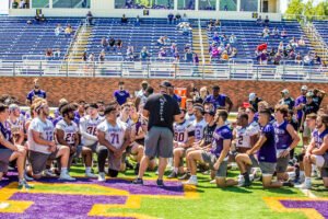 Coach Burleson teaches the team a new play.