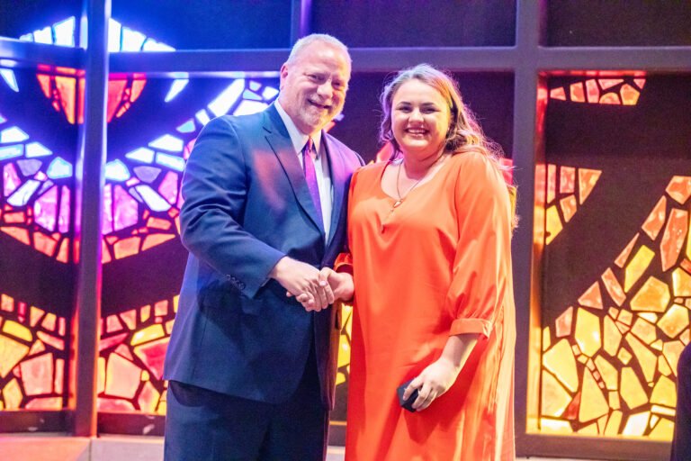 Provost and Chief Academic Officer, Dr. Christopher McNair gives upcoming graduate Scarlett Yates her HSU class ring.