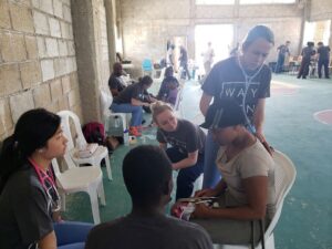 Elizabeth Pullman, center, observes as a PA student cares for a patient in the Dominican Republic.
