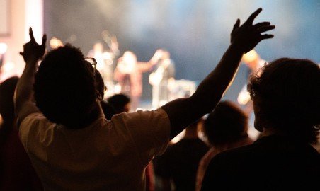 Audience member worshiping during chapel.