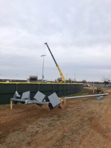 Workers complete the final stages of installing new field lights at the HSU softball field.