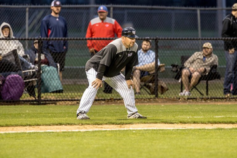 Steve Coleman stands on the field during a game, ready to give instructions to his team.