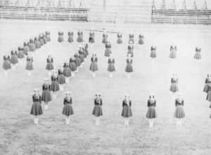 The Cowgirls form a C and a G to represent the name of their organization during a 1959 football game.