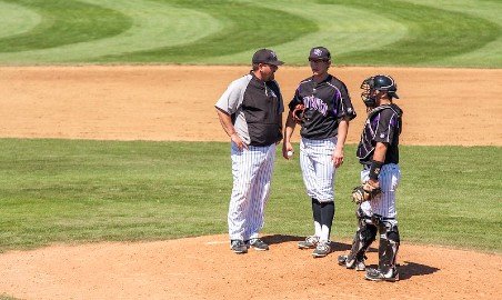 Baseball coach talking to pitcher.