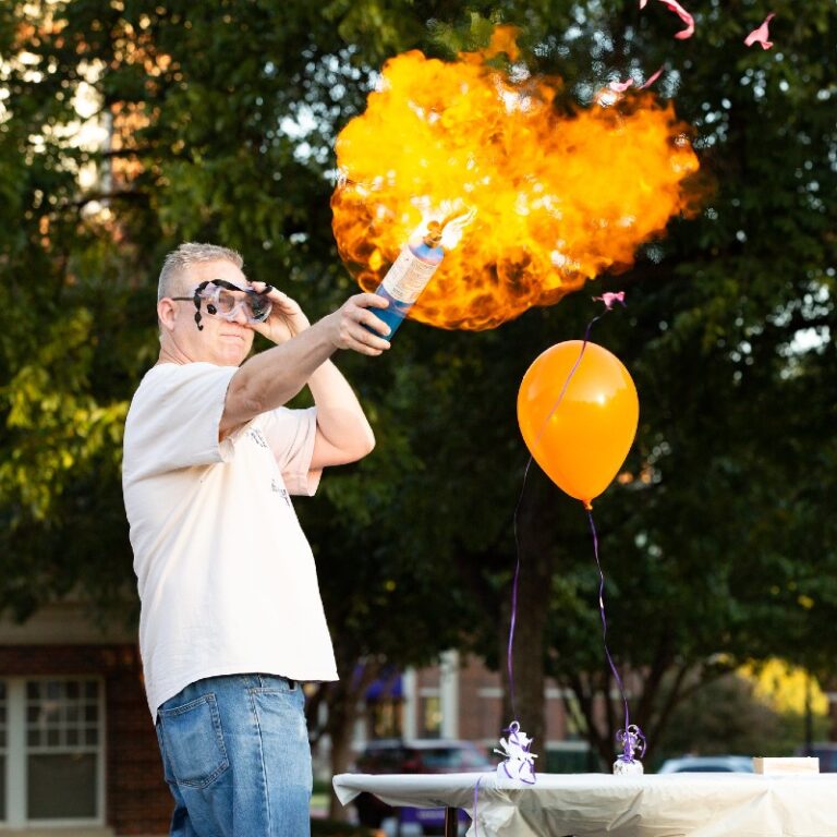 A chemistry professors explodes a balloon in flames.