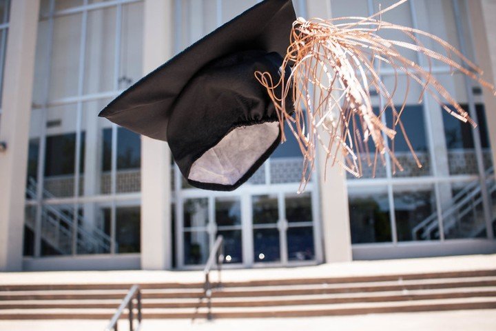 A graduation mortarboard in the air.