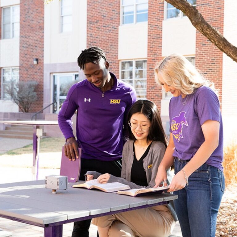 Three students study Bible together.