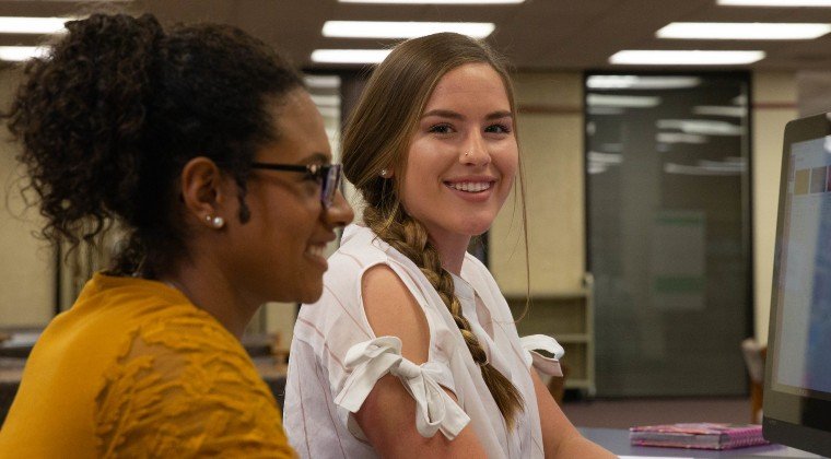 Two female students working on a computer.