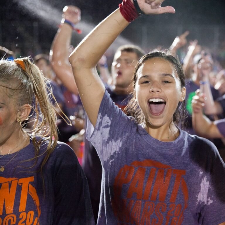 Female student cheering at paint wars.