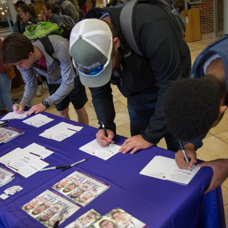 Students sign up at a fair.