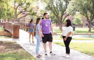 Students chatting on a sidewalk.