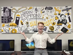 Karson Gopffarth with the mural he pained for the Moody Student Lounge.