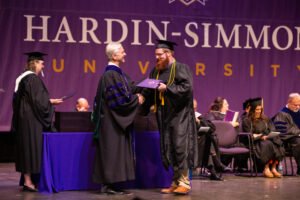 Braxton Weaver shakes President Bruntmyer's hand at graduation.