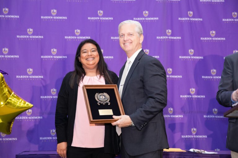 Elizabeth Torres, with her award, stands with Eric Bruntmyer.