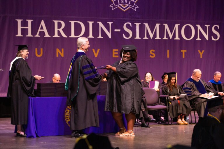 Jai accepts her diploma from President Bruntmyer at graduation.