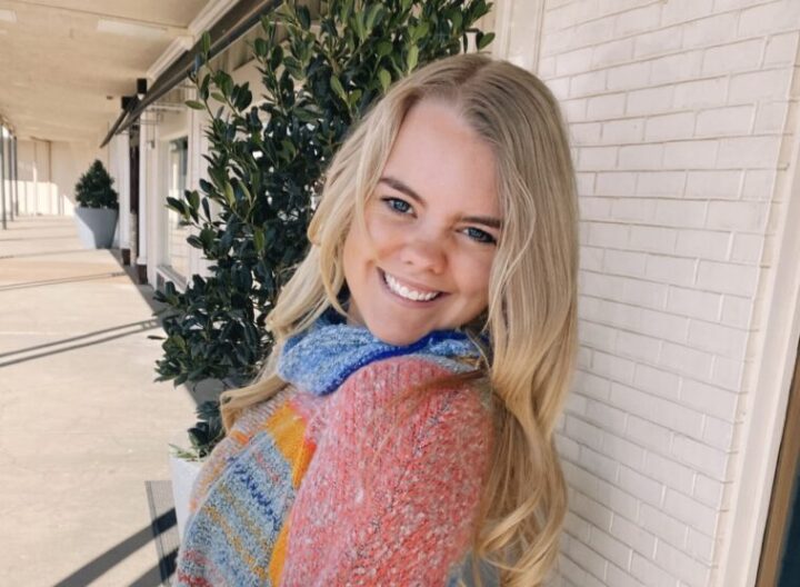 Student Lauren Bell smiles while leaning against a wall.