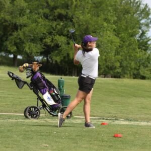 An HSU female golfer swinging.