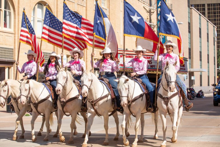 Six White Horse riders on parade in downtown Abilene.