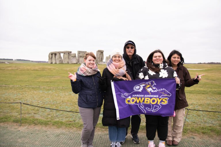 Ashleigh Power, Teresa Vazquez, Dr. Bryan Yorton, Brianne Sams, and Cali Cuevas smile when visiting Stonehenge.