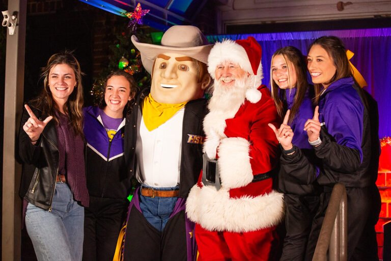 Santa, Hoss, and HSU cheerleaders smile.
