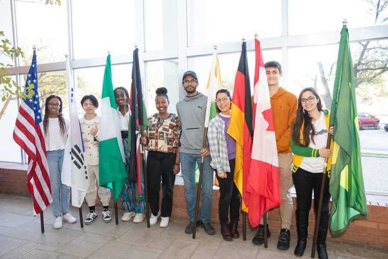 Students stand next to their countries' flags during last year's International Week.