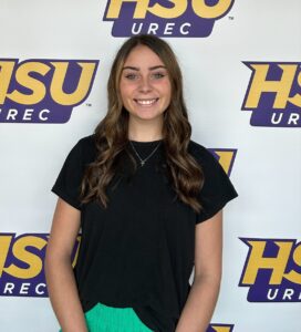Jessica Buford stands in front of an HSU sign