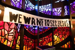 A banner that says, "WE WANT TO SEE JESUS," is hung in Logsdon Chapel.