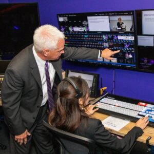 A professor directs a student in digital media.