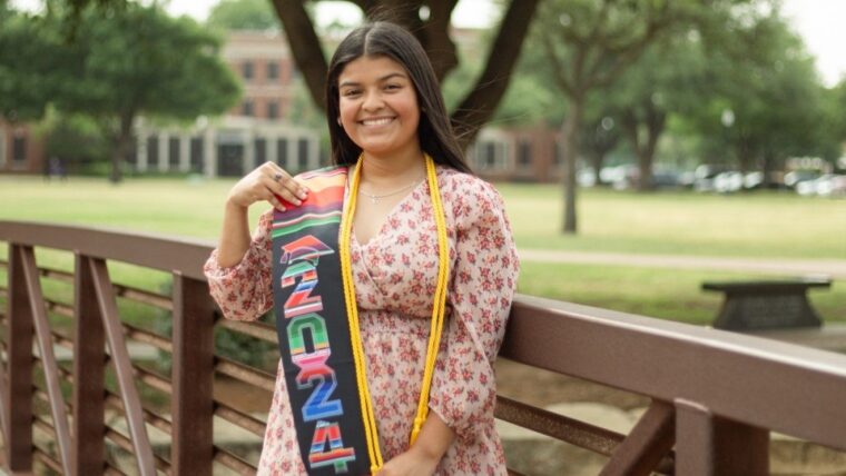 Emily Razo standing on the bridge on campus.