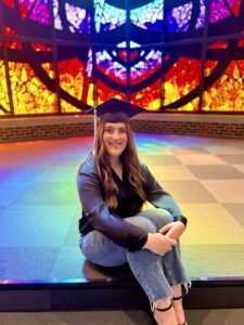 Lainey Burleson sits in Logsdon Chapel with her graduation cap.
