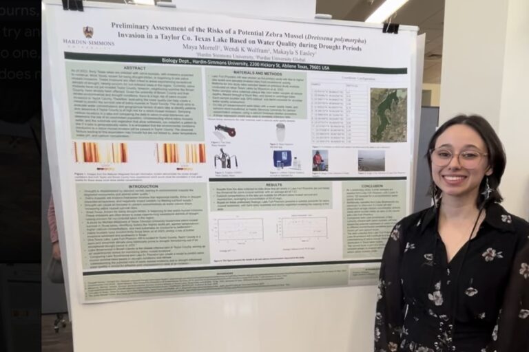 Maya Morell standing next to her scientific diagram which describes the effects of zebra mussels on the local ecosystem.