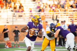 Football quarterback looking for someone to pass the ball to.