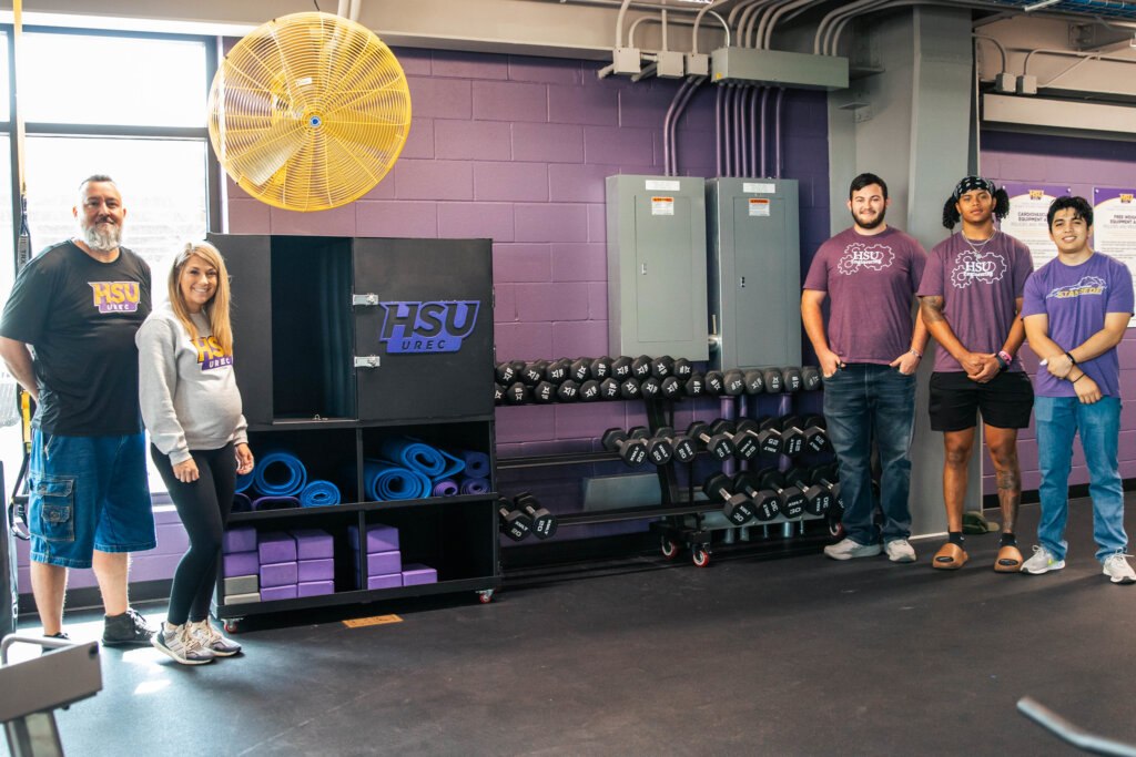 (Pictured Left to Right) Brandon Still, Jeremiah Richard, and Jorge Luis Perales Garcia stand next to their finished project along with University Recreation staff.