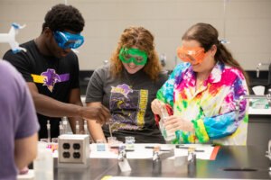 Students working with a professor during a Chemistry lab