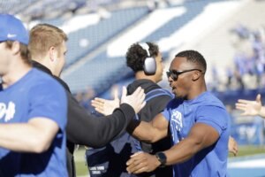 Tim Ismail shares a fired-up moment with BYU athletes on the field — a glimpse into the energy and leadership he brings to the program.