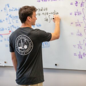 Mathetmatics- boy writing equation on board