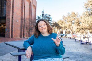 Emliy Slaughter- student feature- girl smiling with the cowboy guns up