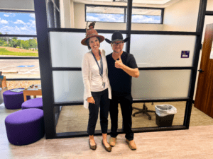 Two people posing for a picture in an office space.