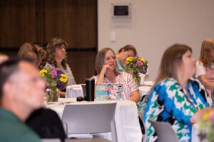 Attendees sitting at a table listening