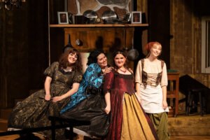 Four actresses perform on stage.